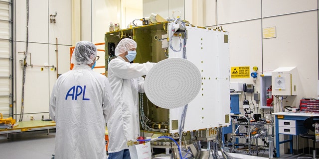 DART team members (from left) John Schellhase, Emory Toomey and Lloyd Ellis of APL inspect the radial line slot array (RLSA) antenna before installing it on the spacecraft.