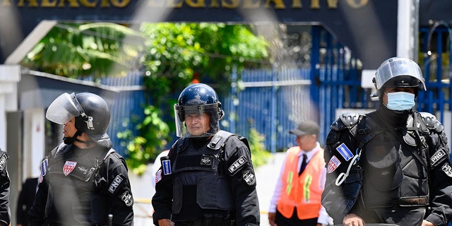A policeman is photographed at the gates of the legislative assembly in San Salvador, El Salvador, on July 26, 2022. Carlos Castro left to escape civil war in his native land. 