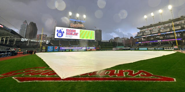 The tarp sits on the field after rain stopped play during the third inning of a game between the Tampa Bay Rays and the Cleveland Guardians at Progressive Field Sept. 27, 2022, in Cleveland.