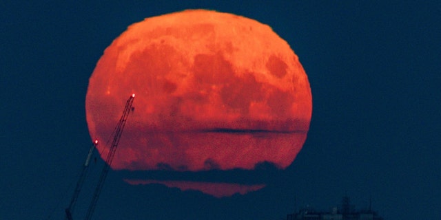 The full moon, also known as the harvest moon, rises above Birmingham, at sunset on Monday. Picture date: Monday September 20, 2021. 