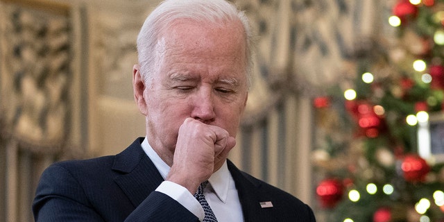 President Biden coughs as he talks to reporters about the November Jobs Report from the State Dining Room of the White House in Washington, D.C., on Dec. 3, 2021.