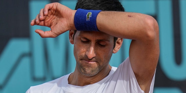 FILE - Novak Djokovic, of Serbia, wipes sweat off during a training session at the Mutua Madrid Open tennis tournament in Madrid, Spain, on April 30, 2022.