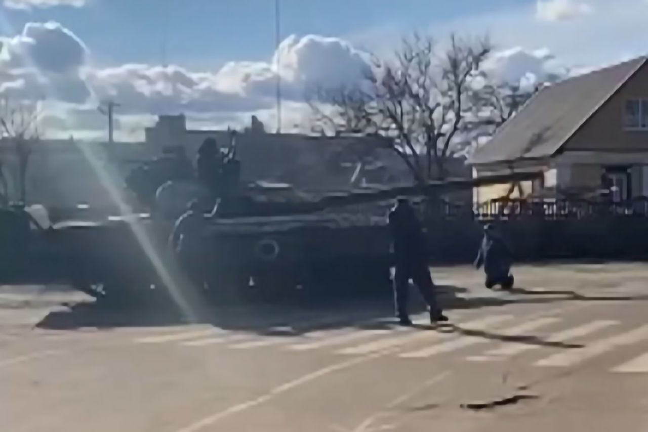 A man kneels in front of a Russian tank in Bakhmach, Ukraine, on February 26 as Ukrainian citizens attempted to stop the tank from moving forward. <a href=