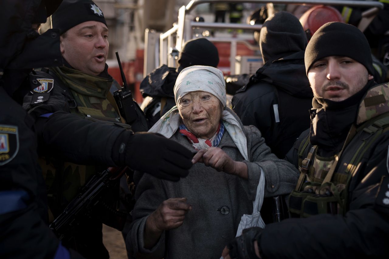An elderly woman is helped by police officers after she was rescued from an apartment that was hit by shelling in Kyiv on March 15.