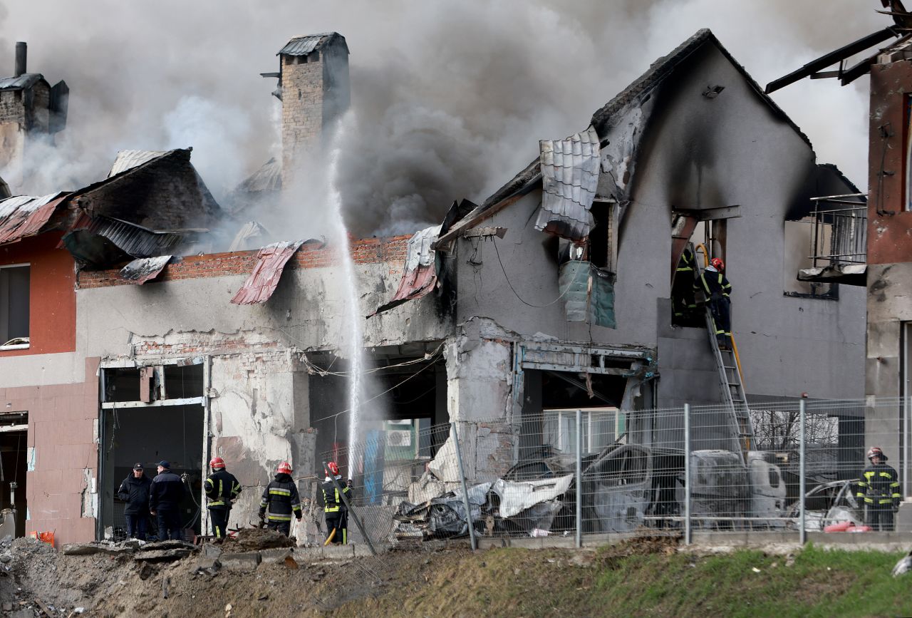 Firefighters work in Lviv after a civilian building was hit by a Russian missile on April 18.