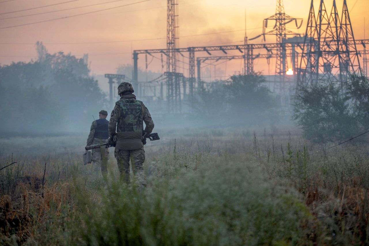 Ukrainian service members patrol an area in the city of <a href=