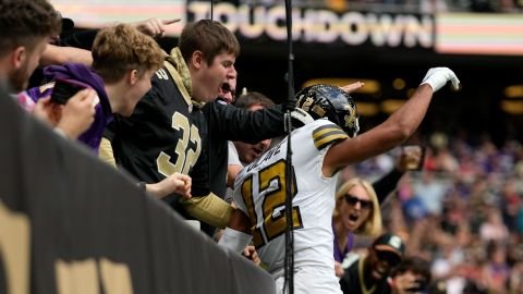 Chris Olave jumps into the crowd after scoring a touchdown against the Vikings. 