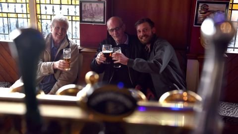Three friends gather at the Cornucopia pub in Southend, England, following the lifting of pandemic restrictions on households mixing indoors, in May 2021.