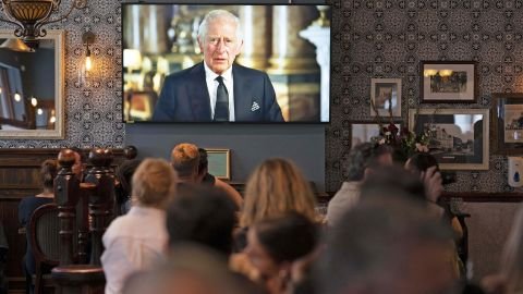 Decades later, a pub in Piccadilly comes to a standstill as patrons watch King Charles III address the nation in his first speech as King of England, in September.