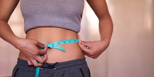 A woman measures her waist. "No drug is without a risk or side effect" — so a doctor’s guidance is always recommended, said Dr. Marc Siegel, even though Ozempic is generally "well-tolerated."