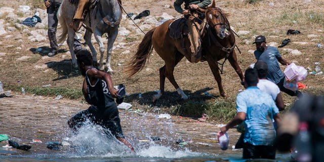U.S. Customs and Border Protection mounted officers attempt to contain migrants as they cross the Rio Grande from Ciudad Acuña, Mexico, into Del Rio, Texas, Sunday, Sept. 19, 2021.