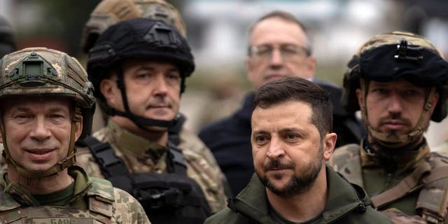 Ukrainian President Volodymyr Zelenskyy poses for a photo with soldiers after attending a national flag-raising ceremony in the freed Izium, Ukraine, Wednesday, Sept. 14, 2022. 