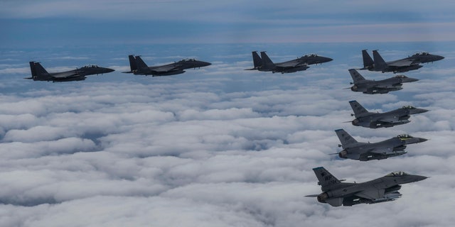 In this photo provided by South Korea Defense Ministry, South Korean Air Force's F15K fighter jets and U.S. Air Force's F-16 fighter jets, fly in formation during a joint drill in an undisclosed location in South Korea, Tuesday, Oct. 4, 2022. (South Korea Defense Ministry via AP)