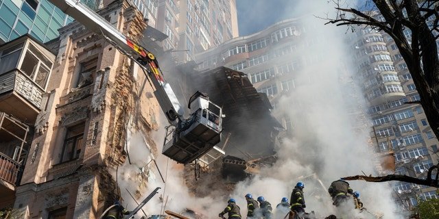 Firefighters work after a drone attack on buildings in Kyiv, Ukraine, Oct. 17, 2022.