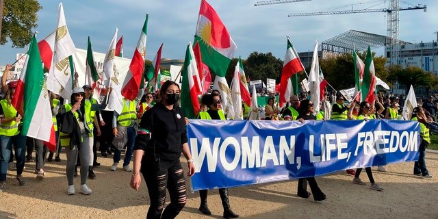 People carry a sign that reads "Woman, Life, Freedom," as hundreds rally on Saturday, Oct. 22, 2022, in Washington in a show of international support for demonstrators facing a violent government crackdown in Iran, sparked by the death of 22-year-old Mahsa Amini in the custody of that country's morality police.