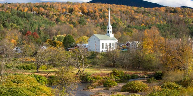 Typical New England scene: Stowe Church in a landscape of fall foliage colors in Stowe, Vermont. The ski resort town is a powerhouse of American beer making as the home of critically acclaimed The Alchemist and Von Trapp Brewing.