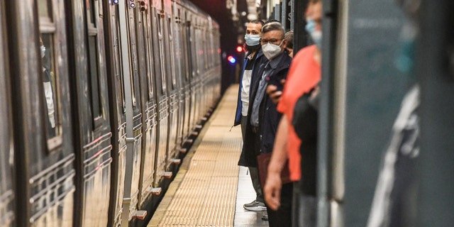 Commuters wait on the platform at the Times Square subway station in New York City, on Wednesday, May 25, 2022.