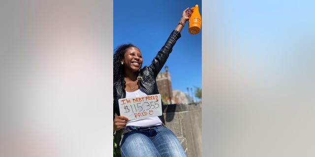 Micah is shown celebrating in this photo after she paid off $115,355 in student loan debt. She told her friends during college that she had to have a job — and actually held three jobs per semester in her sophomore, junior and senior years of college, she said.