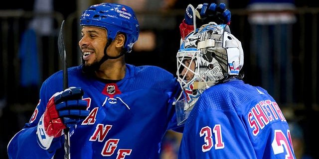 New York Rangers right wing Ryan Reaves, left, and goaltender Igor Shesterkin (31) celebrate following the team's 3-1 win in a game against the Tampa Bay Lightning Oct. 11, 2022, in New York.