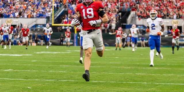 Brock Bowers (19) of the Georgia Bulldogs catches a pass and runs into the end zone for a touchdown during the first half of a game against the Florida Gators at TIAA Bank Field Oct. 29, 2022, in Jacksonville, Fla.