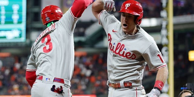 Bryce Harper #3 and J.T. Realmuto #10 of the Philadelphia Phillies celebrate after Realmuto hit a home run in the 10th inning against the Houston Astros in Game One of the 2022 World Series at Minute Maid Park on October 28, 2022 in Houston, Texas.