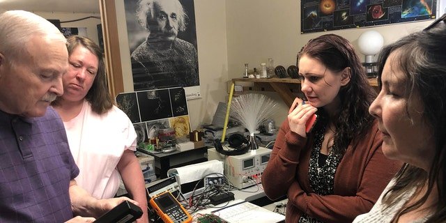 PI-NE team members are shown in a lab working on one of their cases.