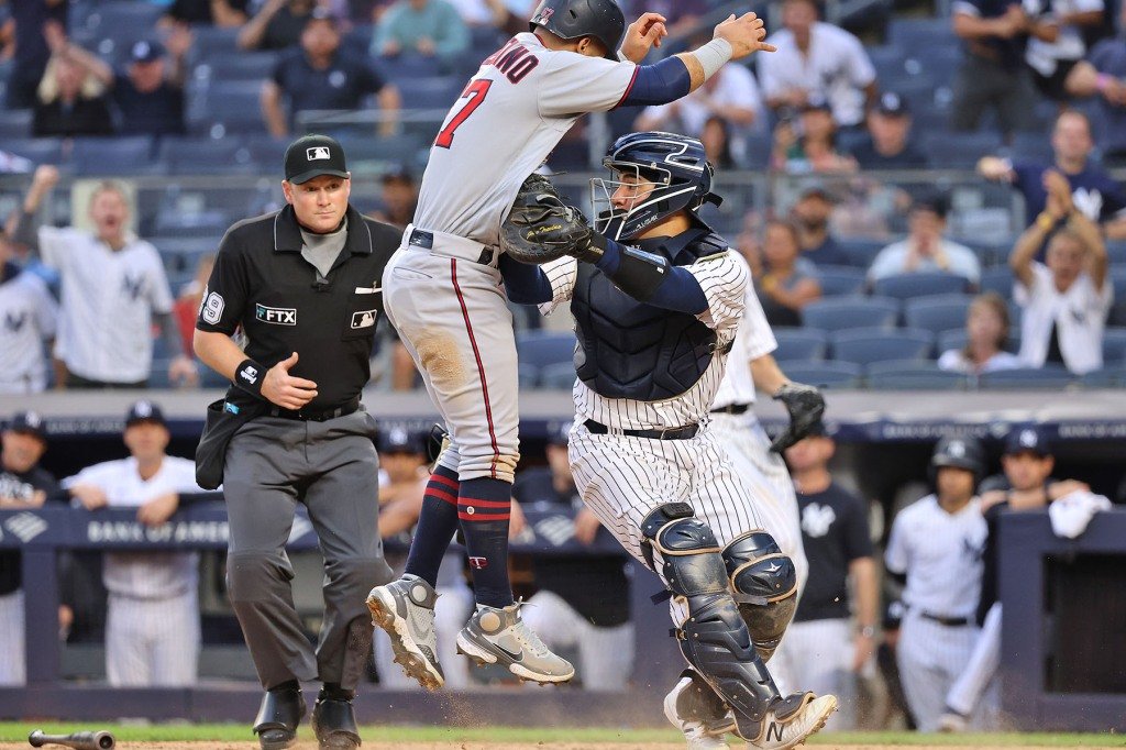 Minnesota Twins center fielder Gilberto Celestino #67 is tagged out by New York Yankees catcher Jose Trevino #39 trying to score during the 10th inning.