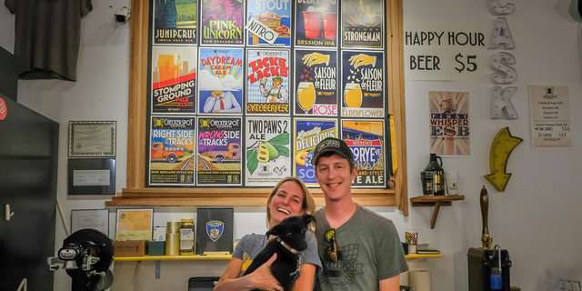 Judy and Rob Neff hold their dog, Dixie, at Checkerspot Brewery in Baltimore, Maryland.