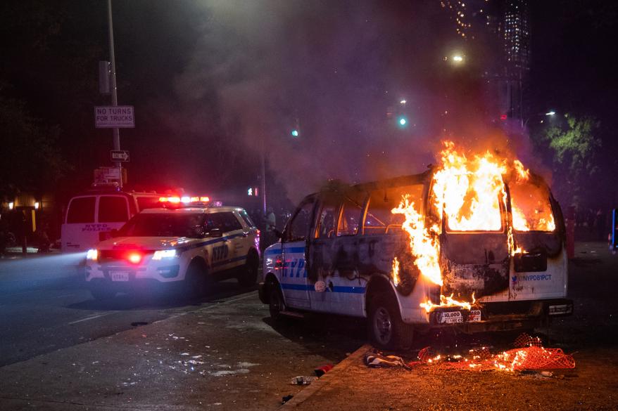 A picture of an NYPD police van on fire in Brooklyn.
