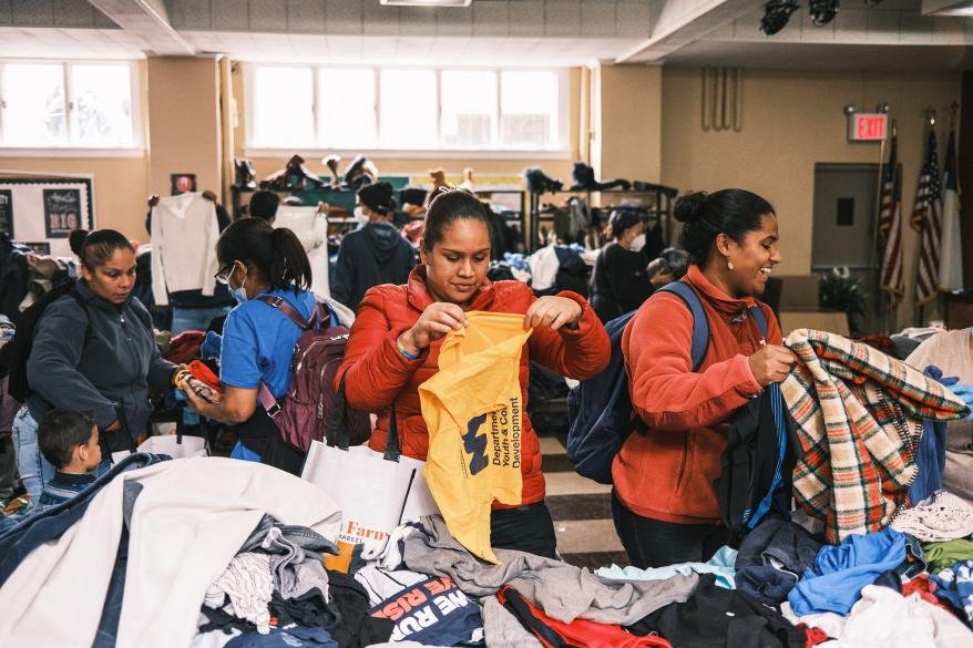 Images of migrant families receiving clothing donations.
