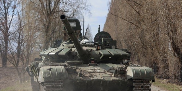 A Ukrainian service member drives a captured Russian T-72 tank, as Russia's attack on Ukraine continues, in the recently liberated village of Lukianivka, in Kyiv region, Ukraine March 27, 2022. REUTERS/Serhii Nuzhnenko