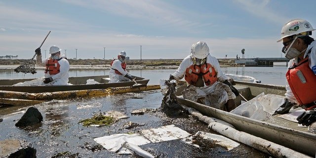 Cleanup contractors deploy skimmers and floating barriers known as booms to try to stop further oil crude incursion into the Wetlands Talbert Marsh in Huntington Beach, Calif., Sunday., Oct. 3, 2021. One of the largest oil spills in recent Southern California history fouled popular beaches and killed wildlife while crews scrambled Sunday to contain the crude before it spread further into protected wetlands. (AP Photo/Ringo H.W. Chiu)