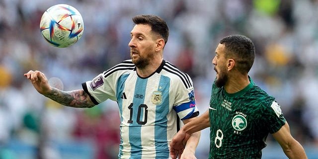 Argentina's Lionel Messi, left, and Saudi Arabia's Abdulelha Al-Malki, fight for the ball during the World Cup group C soccer match between Argentina and Saudi Arabia at the Lusail Stadium in Lusail, Qatar, Tuesday, Nov. 22, 2022.