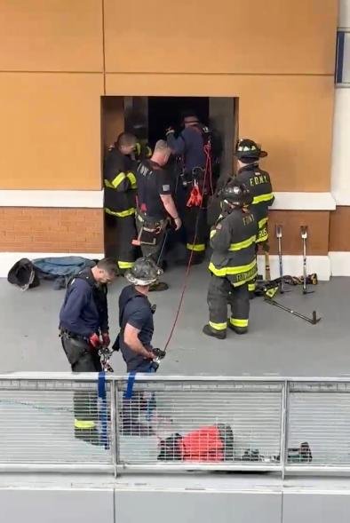 A picture of rescue teams trying to reach two people that fell down an elevator shaft.