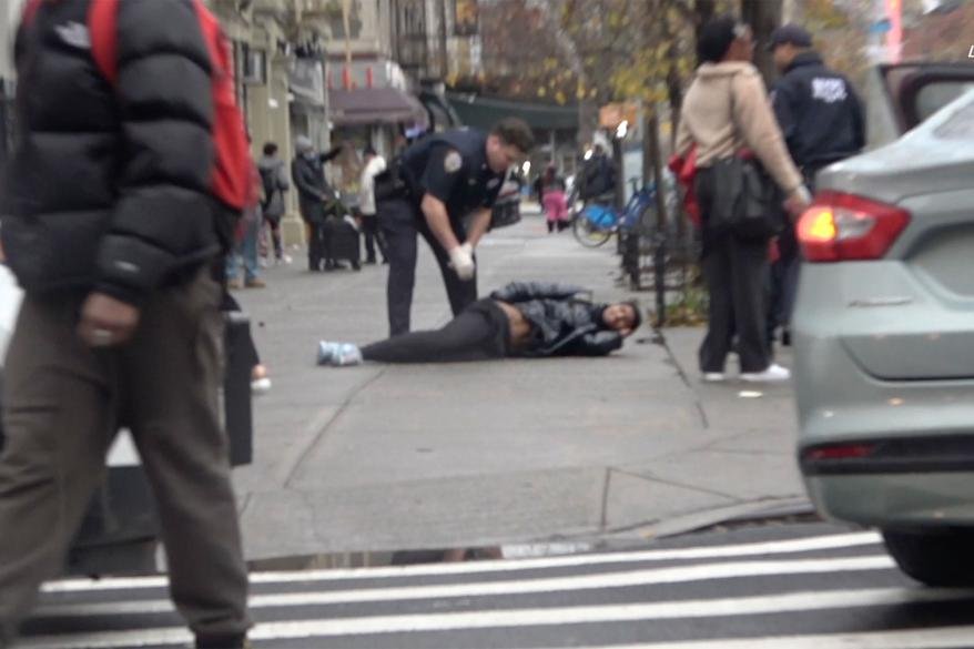 A police officer with the Harlem shooting victim.