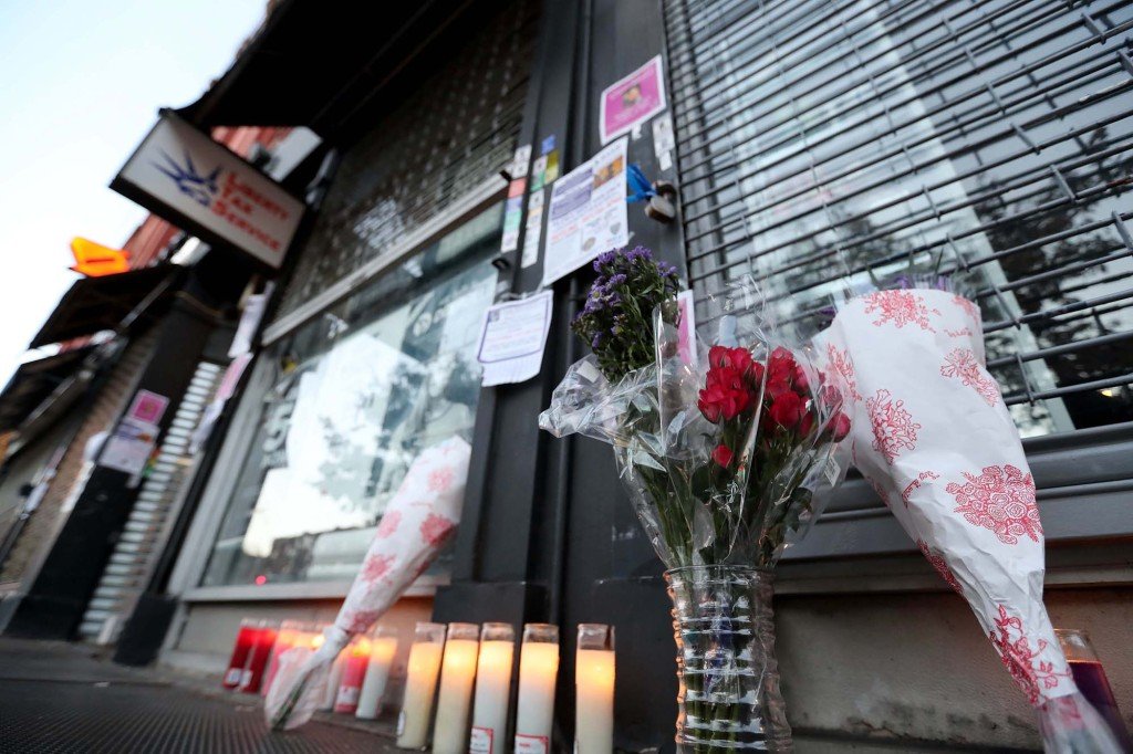 Candles and flowers are left in memory of 16-year-old Saniyah Lawrence outside the building where she was killed.