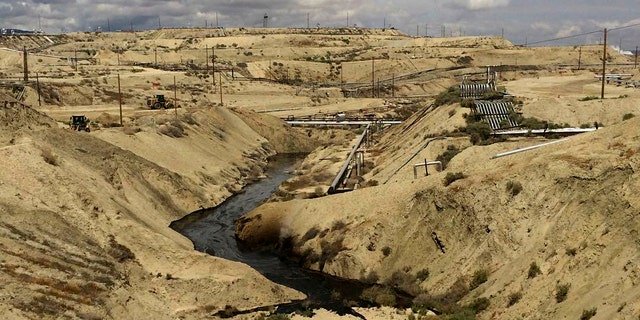 In this May 10, 2019 photo provided by the California Department of Fish and Wildlife's Office of Spill Prevention and Response, oil flows at a Chevron oil field in Kern County, Calif. Nearly 800,000 gallons of oil and water has seeped from the ground since May. Chevron and California officials say the spill is not near any waterway and has not significantly affected wildlife. (California Deptartment of Fish and Wildlife's Office of Spill Prevention and Response via AP)