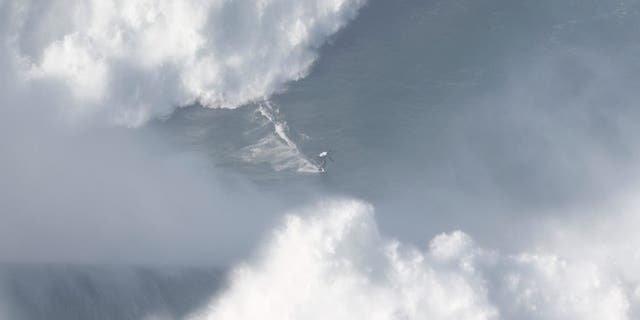 A surfer rides a wave in Praia do Norte, Nazare, Portugal, Jan. 8, 2022.