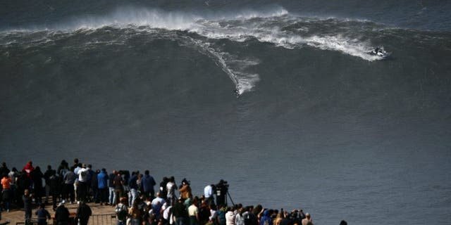 A surfer rides a wave in Praia do Norte, Nazare, Portugal, February 25, 2022.