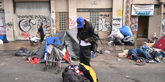 Homeless people stand with their belongings in front of an outpatient mental health clinic in Los Angeles, California, on Dec. 6, 2022.