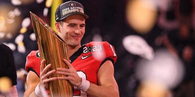 Georgia Bulldogs quarterback Stetson Bennett holds the championship trophy on Jan. 9, 2023, at SoFi Stadium in Inglewood, California.