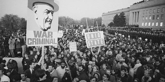 Peace demonstrators display a sign referring to the president as a war criminal during a huge anti-Vietnam war protest at the Pentagon in Washington, D.C.