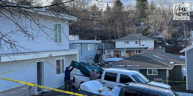 Individuals remove items including a mattress from the home where four University of Idaho students were murdered on Nov. 13, 2022.