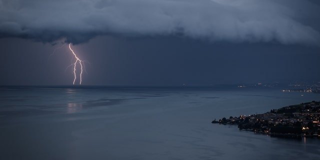 Lightning illuminates Lake Geneva next to the village of Cully during a storm seen from Chexbres, western Switzerland, on August 16, 2020.