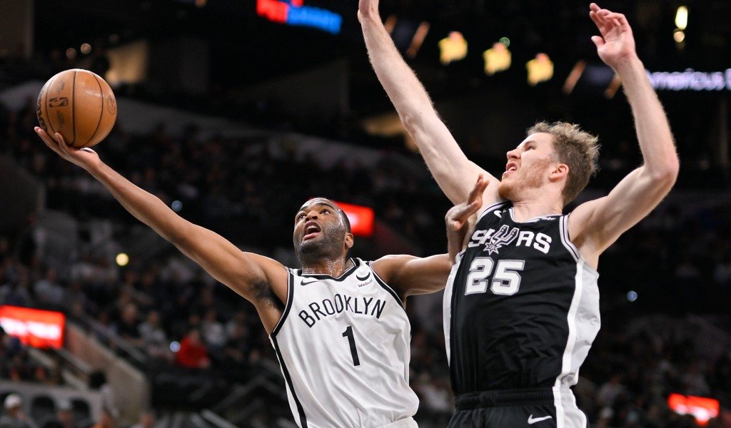 T.J. Warren goes up for a shot as the Spurs' Jakob Poeltl defends during the Nets' loss.