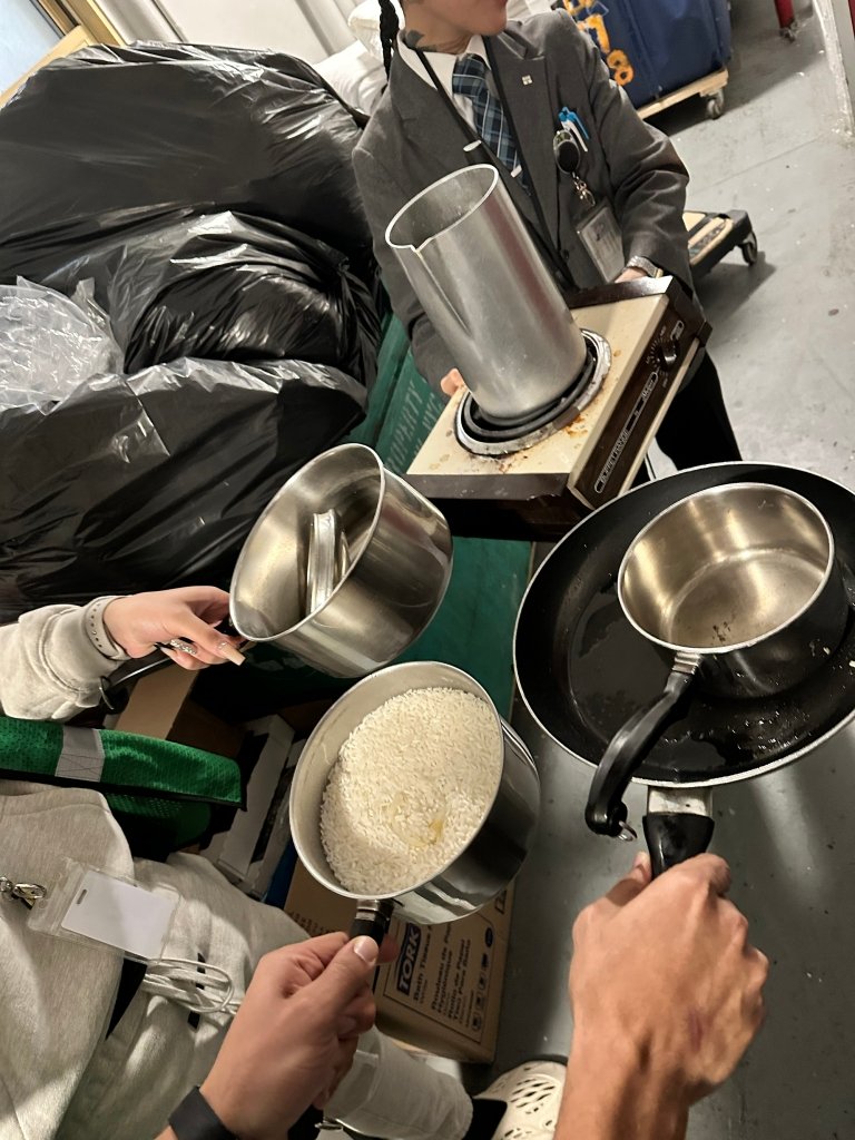 Residents cooking food in a hotel room at Row NYC with a hot plate.