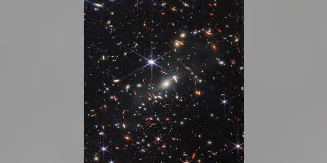 The first image released from the James Webb Space Telescope shows galaxies around each other whose light has been bent, NASA officials said.