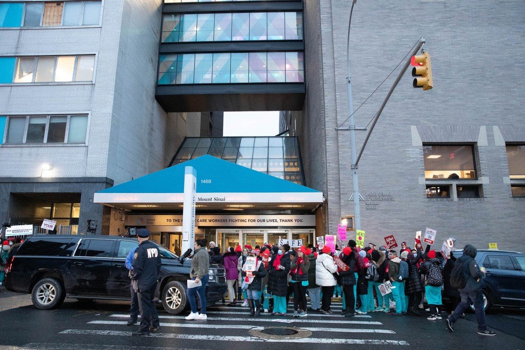 Dozens of nurses gather outside of Mount Sinai Hospital with signs demanding a fair contract and better patient care.