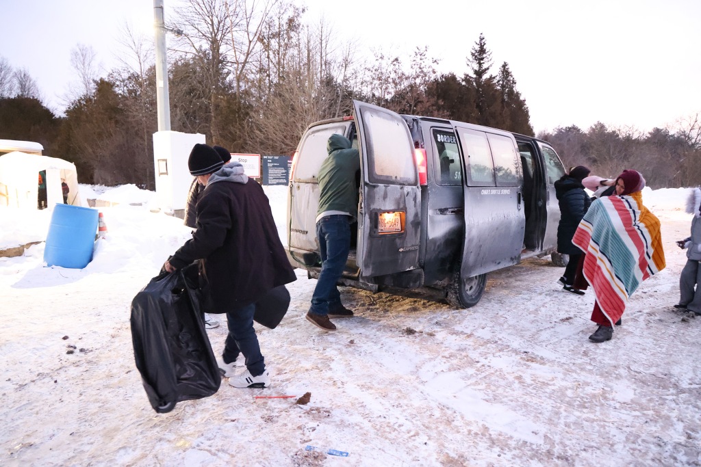 Migrants get out of a van in Plattsburgh. 