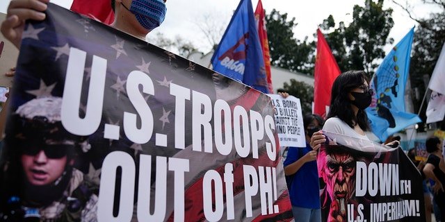 Demonstrators hold banners as they protest against the visit of U.S. Defense Secretary Lloyd Austin outside Camp Aguinaldo military headquarters in metro Manila, Philippines on Thursday, Feb. 2, 2023.